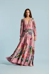 Vestido largo Natalia Antolin de color rosado con estampado floral y de aves, escote en V profundo, mangas largas abullonadas con puños y lazo ajustable en la cintura.