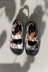 Sandalias de plataforma estilo chunky en color negro, confeccionadas en material sintético efecto charol. Presentan dos tiras ajustables con hebillas metálicas plateadas y una tira trasera con hebilla para mayor sujeción. Suela dentada de goma.