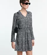 Vestido corto camisero de crepé con estampado abstracto en blanco y negro, cuello con solapa, mangas largas y lazo en la cintura.