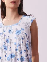 Conjunto de pijama marca René Rofé, compuesto por remera de mangas cortas con escote en V abotonado y pantalón capri con cintura elastizada. Diseño estampado con flores azules sobre fondo blanco.
