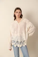 Camisa color crema con bordados florales, de corte holgado y mangas largas.