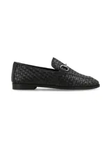 Mocasines negros de cuero con diseño entrelazado, detalle de estribo metálico en el empeine y suela plana.