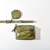 Bandolera verde con correa ajustable, monedero circular y diseño acolchado con pespuntes en forma de rombos.