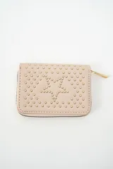 Billetera pequeña con cierre, color negro, decorada con tachas doradas que forman una estrella central y cubren el resto de la superficie. Posee un tirador de cierre metálico dorado.