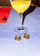 Par de aros dorados con forma de espiral, hechos de acero quirúrgico hipoalergénico.