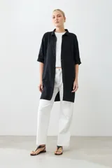 Túnica negra con bordados y bolsillos laterales.