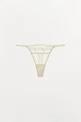 Tanga de tiro medio confeccionada en algodón con detalles de encaje floral a tono y laterales de elástico fino.