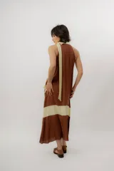 Vestido largo color marrón con detalles en tono marfil, escote halter y lazo largo en el cuello.