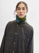 Trench oversize de lana a cuadros con cuello, puños y bolsillos de pana verde.