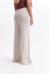 Pantalón de punto color ladrillo con diseño calado, cintura elástica y corte palazzo.