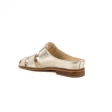 Zueco de cuero metalizado dorado, diseño artesanal con capellada en tiritas cruzadas estilo romano y talón descubierto con suela plana y pequeño taco de madera.