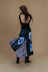 Falda larga de seda negra con estampado floral azul y detalles de tela escocesa en el ruedo.