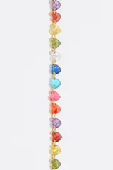 Pulsera de cadena fina dorada de acero inoxidable con una hilera de cristales de vidrio en forma de corazón de múltiples colores. Incluye cierre de mosquetón ajustable y dije de la marca.