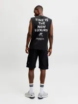 Musculosa negra de algodón con cuello redondo, calce holgado y pequeño estampado frontal con el texto "CORE 1990".