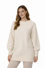 Vestido mini de punto color crema, con cuello asimétrico, mangas largas con puños ajustados y diseño holgado.