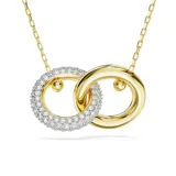 Colgante dorado con dos aros entrelazados, uno de ellos con pavé de cristales blancos. La cadena tiene un cristal Swarovski en el extremo.