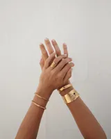 Pulsera tipo esclava abierta con diseño rústico y acabado irregular, fabricada en bronce y alpaca.