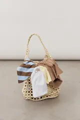 Cartera tipo shopper confeccionada en cuentas de madera de color crudo, con diseño de red y asas de hombro.