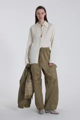 Pantalón cargo verde oliva de corte amplio con cintura elastizada ajustable con cordón y bolsillos laterales con solapa.