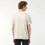 Remera beige de manga corta con estampado de una ciudad y texto en blanco y negro.