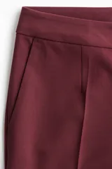 Pantalón sastrero de tiro alto, color bordó, con piernas rectas y pliegues marcados en el frente.