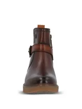 Botines de cuero color marrón oscuro, con diseño de caña media, cierre lateral y una tira decorativa con hebilla metálica sobre el empeine. Presentan una suela de goma texturizada en tono natural y un pequeño logo metálico en la parte superior de la caña.