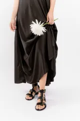 Sandalia de cuero vacuno color negro, con múltiples tiras y hebillas metálicas ajustables. Tiene taco bajo, forro y plantilla de cuero, y suela sintética.