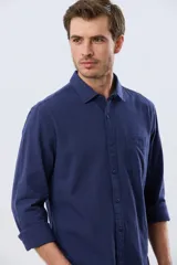 Camisa de lino de manga larga en color beige, con cuello camisero, cierre frontal de botones y un bolsillo ojal en el pecho.