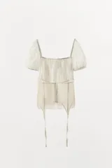 Top blanco de escote cuadrado y mangas cortas abullonadas, con diseño combinado de tejido fruncido en la parte superior y corsé con encaje y cintas colgantes en la parte inferior.