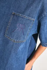 Vestido corto de denim azul con corte en A, mangas cortas y bolsillo en el delantero con isologo doble R bordado a tono.
