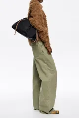 Bolso de hombro Bimba y Lola de tamaño grande, confeccionado en nylon negro con estructura blanda. Presenta dos asas largas, cierre superior y detalles de cordones laterales en tonos tierra. Incluye un parche frontal con el logo de la marca grabado.