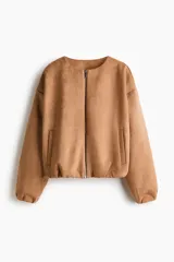 Chaqueta de punto pesado color tostado, con escote redondo, cierre frontal y bolsillos laterales. Presenta un diseño oversized con hombros caídos y terminaciones elásticas en puños y bajo.
