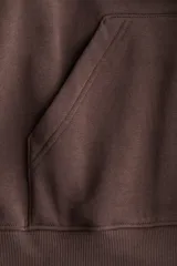 Buzo con capucha de doble capa, hombros marcadamente caídos y bolsillo canguro. Puños y bajo acanalados.