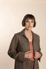 Camisa larga color beige con botones dorados y bolsillo plaque en la delantera. Confeccionada en lana fina sin teñir, diseñada exclusivamente por Don Baez. Hecha 100% en Uruguay.