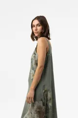 Vestido largo verde militar con estampado floral, silueta amplia, escote redondo y tirantes finos con detalle de botones.