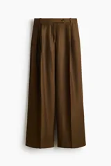 Pantalón sastrero de corte ancho, color marrón, con pinzas frontales, trabillas para cinturón y raya marcada en las piernas.