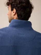 Chaleco de polar azul con cierre frontal completo, cuello alto y bolsillos laterales con cierre.