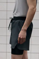 Short deportivo de doble capa con tecnología DryMove para absorción de sudor. Cuenta con una capa exterior de corte estándar con cintura elástica, cordón de ajuste, bolsillos laterales y aberturas en el bajo. Incluye una calza interior tipo biker con bolsillo lateral y un bucle trasero para accesorios.