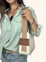 Bolso tipo baguette color crudo con doble correa al hombro de cuero color camel.