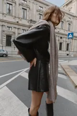 Falda pantalón negra de tiro alto con efecto piel desgastado y abertura frontal. Presenta costuras visibles en el centro y laterales.