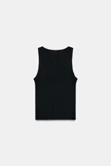 Musculosa de punto rib color blanco, con escote redondo y diseño ajustado.