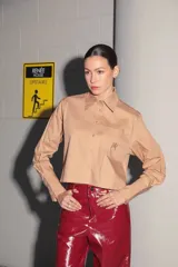 Camisa color camel de poplin de algodón, manga larga y largo a la cintura. Tiene un bolsillo bordado con el isologo de Renée a tono.