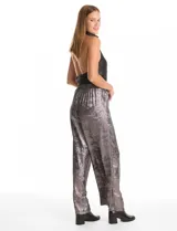 Pantalón wide leg de tela laminada metalizada color blanco, con pretina elástica y lazo de ajuste en la cintura. Cuenta con bolsillos laterales.