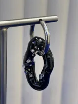 Aros colgantes de diseño orgánico en color negro con incrustaciones de vidrio brillante, montados sobre argollas de plata 925.