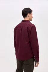 Sobrecamisa de algodón color bordó, con cuello solapa, cierre frontal con botones y dos bolsillos en el pecho con tapa.