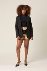 Blazer negro de corte sastre, con solapas de muesca, cierre frontal con un botón y bolsillos delanteros con solapa.