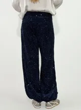 Pantalon de corte recto y holgado, confeccionado en tela cubierta de lentejuelas brillantes en color azul oscuro, con forro interior.