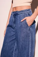Pantalón de jean azul de tiro bajo y corte wide leg.
