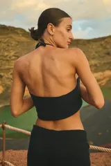 Top tejido negro con breteles finos y escote halter.