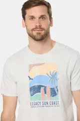 Remera de manga corta color gris con estampado de paisaje costero con palmeras y tablas de surf.